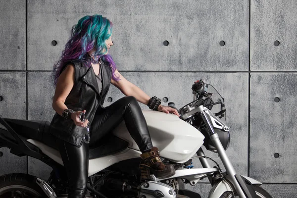 Biker chick framför motorcykel. Vacker och PERT ung kvinna i läderkläder — Stockfoto