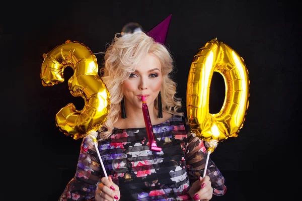 Молодая привлекательная блондинка празднует свое 30-летие. Веселая блондинка с золотыми шариками. День рождения — стоковое фото