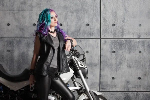 Cool girl in leather clothes near the motorcycle. Young stylish woman with colored hair on the bike. — Stock Photo, Image