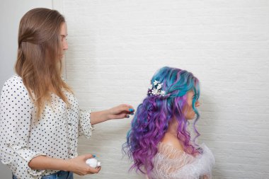 uzun bukleler üzerinde stil yapıyor saç stilisti. Parlak çok renkli saç boyama