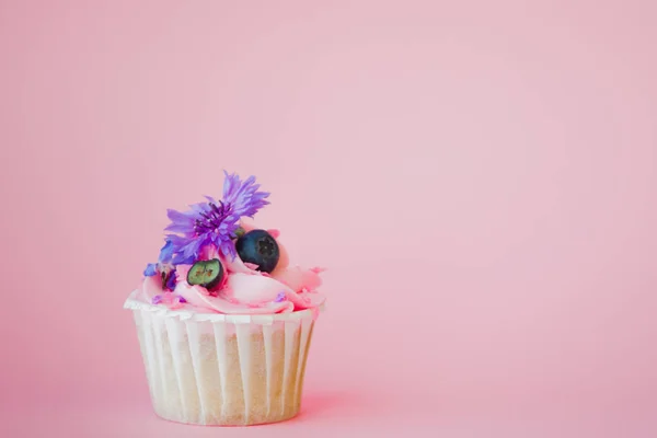 Süßes Dessert auf rosa Hintergrund, Kopierraum. Cupcake mit Sahne, schön und lecker. — Stockfoto