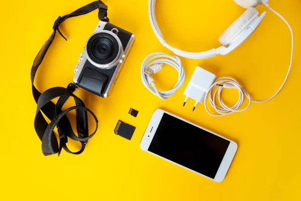 Camera for a photographer, headphones accessories and charger and the smartphone — Stock Photo, Image