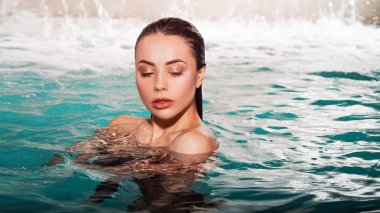 Havuzda yüzen güzel genç kadın, portre.