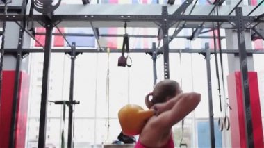 Kettlebell Fitness, spor salonunda güç egzersizleri yapan genç kadın atlet