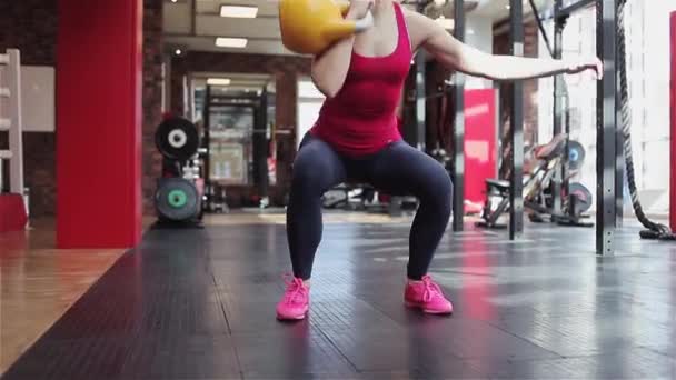 Kettlebell fitness, młoda kobieta sportowiec robi ćwiczenia siłowe w siłowni — Wideo stockowe