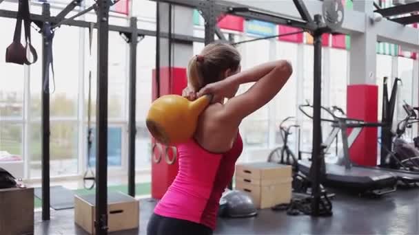 Kettlebell Fitness, spor salonunda güç egzersizleri yapan genç kadın atlet — Stok video