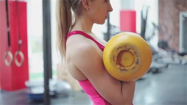 Kettlebell fitness, jonge vrouwelijke atleet doen kracht oefeningen in de sportschool — Stockvideo