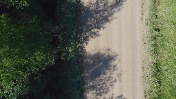 자전거를 탄 소녀가 마을의 비포장 도로를 타고 있다. 자연, 숲에서 자전거 타기. — 비디오