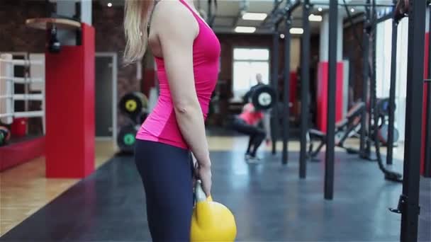 Kettlebell Fitness, spor salonunda güç egzersizleri yapan genç kadın atlet — Stok video