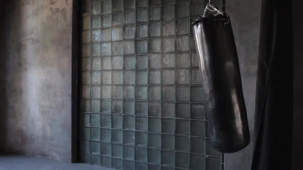 Palestra grunge scuro, sacco da boxe oscillante dal calcio, nessuno . — Video Stock