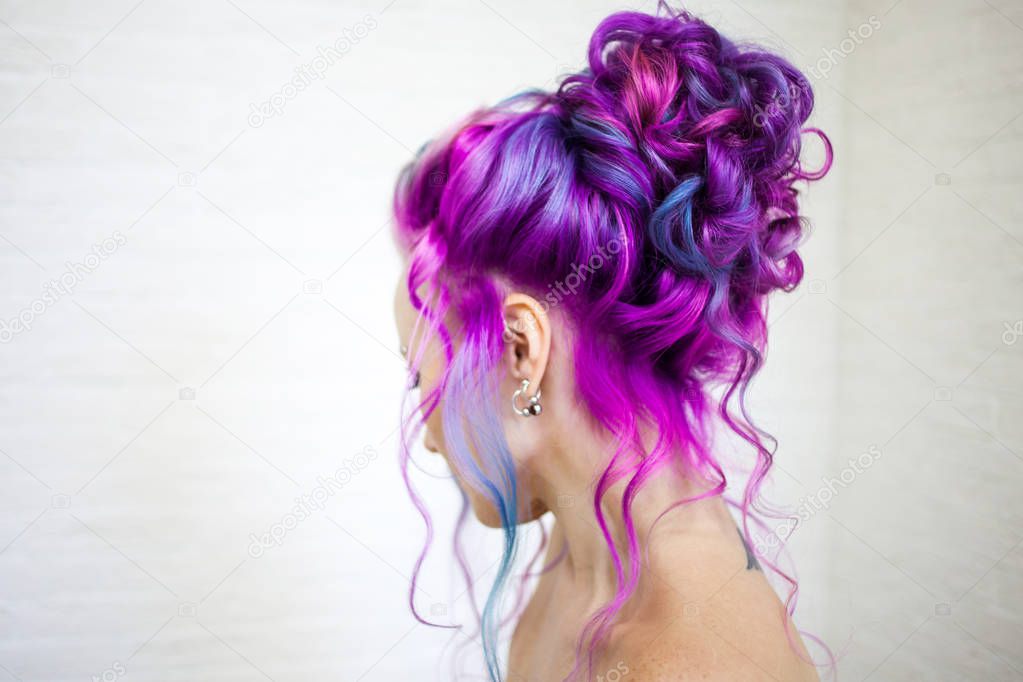 Portrait of a young beautiful woman with colored hair. Bright shades of blue and purple, gradient hair.