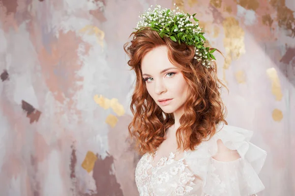 Retrato de uma jovem mulher bonita em vestido de noiva com coroa de flores frescas . — Fotografia de Stock