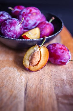 Masanın üzerinde bir tabaklezzetli sulu mavi erik, dokulu ahşap masa,
