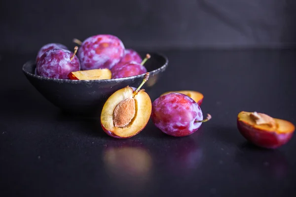 Leckere saftige blaue Pflaumen in einer Schüssel auf dem Tisch, — Stockfoto