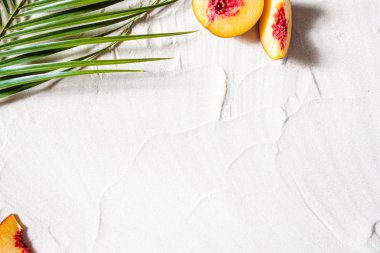 Sahil tatili. Bir palmiye yaprağı ve sulu meyveler beyaz ince kum üzerinde yatıyor. Masaüstü duvar kağıdı.