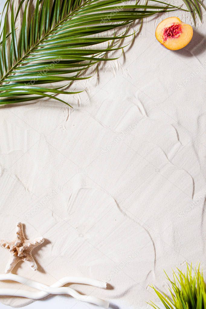 Beach vacation. A palm leaf, starfish, and white tree branch and juicy fruits lie on white fine sand. Desktop wallpaper.