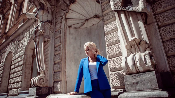 Spaziergang durch das historische Zentrum. schönes Mädchen, blond mit Pferdeschwanz im blauen Strumpfanzug, gegen historische Gebäude. — Stockfoto