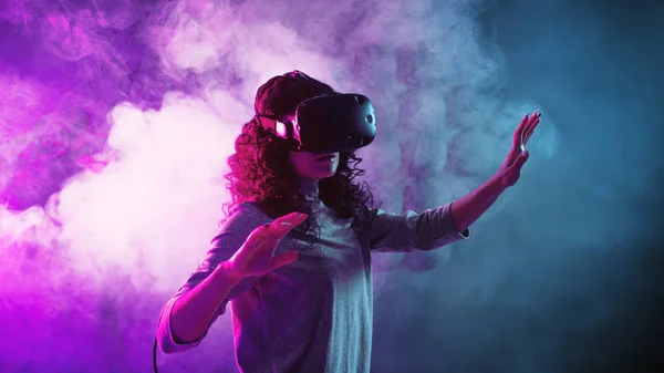 Hra na virtuální realitu. Dívka ve VR hraje hru nebo prozkoumává životní prostředí. — Stock fotografie