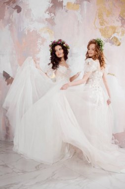 Başlarına güzel bahar çelenkiki büyüleyici gelinler. Gelinlik güzel genç kadınlar