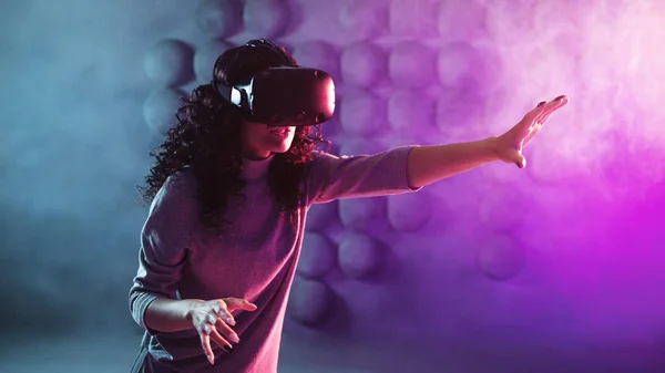 Virtual reality game. A girl in a VR helmet plays a game or explores the environment.