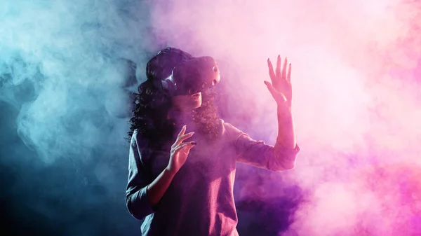 Juego de realidad virtual. Una chica con casco VR juega un juego o explora el entorno . —  Fotos de Stock