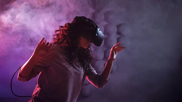 Jeu de réalité virtuelle. Une fille dans un casque VR joue à un jeu ou explore l'environnement . — Photo