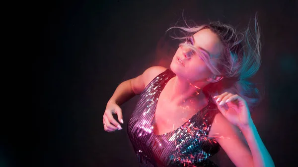 Aantrekkelijke dansende blonde in de club, neon light bewegingseffecten — Stockfoto