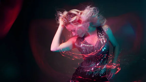 Привлекательная танцующая блондинка в клубе, неоновый свет, эффекты движения — стоковое фото