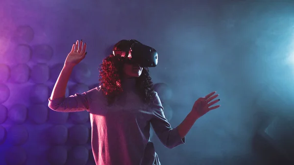 Gamer em realidade virtual, uma menina joga um jogo ou explora o ambiente em uma simulação . — Fotografia de Stock