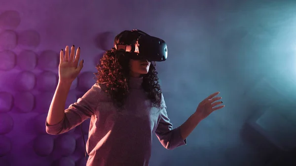Gamer en réalité virtuelle, une fille joue un jeu ou explore l'environnement dans une simulation . — Photo