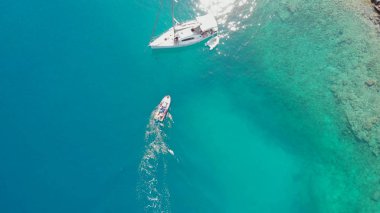 Kıyıya demirli yelkenli yatı, çok güzel bir deniz manzaralı drone resmi..