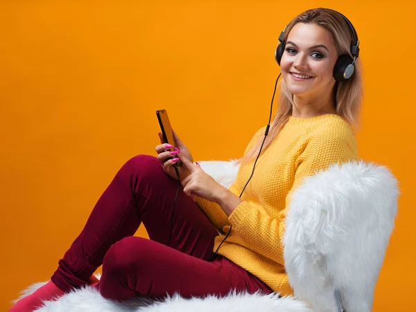 Loira feliz e alegre com o telefone e fones de ouvido usa comunicação de voz e leva uma lição on-line — Fotografia de Stock