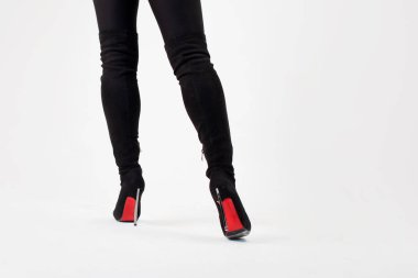 Diz boyu siyah çizmeler içinde ince bacaklar. Seksi tarz, vücut parçaları açık