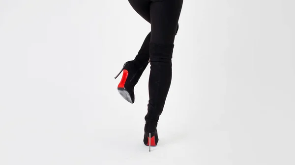 Slanke benen in zwarte laarzen en broek. Lopen op hoge hakken. Stiletto schoenen — Stockfoto