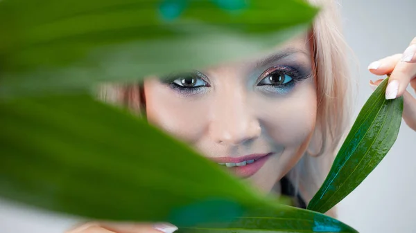 Cosmetici naturali, concetto. Affascinante bionda fa i petali della pianta agli occhi , — Foto Stock