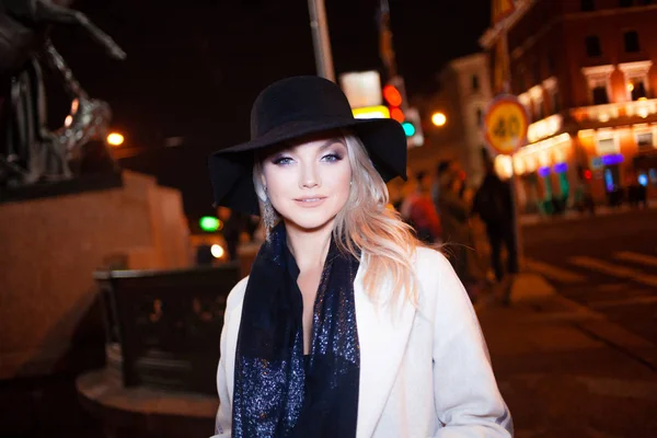 Jeune femme élégante et élégante en manteau beige et chapeau noir sur la ville — Photo