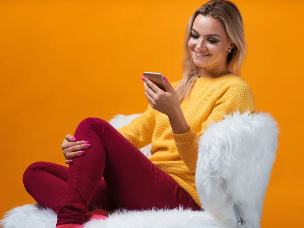 Rubia feliz y alegre utiliza smartphone para la comunicación y las compras en línea . — Foto de Stock