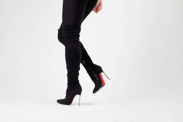 Slim legs in knee-high black boots. Sexy style, body parts on