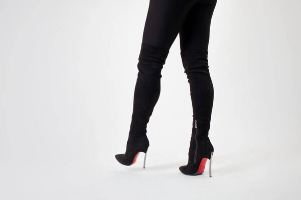 Slim legs in black boots and pants. Walking in high heels. Stiletto shoes