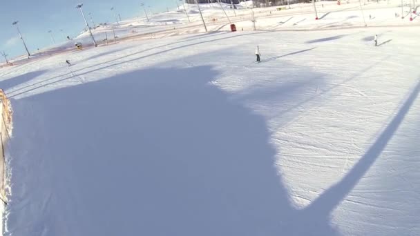 Lyžaři a snowboardisté sestupují ze svahu. Lyžařské středisko, aktivní rekreace v zimě. — Stock video