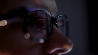 Monitörde çalışan programcı ve analist, kod yazıyor. Gözlüklerdeki monitör yansıması