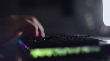 Karanlık bir odada arka plandaki klavyeye kod yazma programcısı, bilgisayardaki tutkulu çalışma.