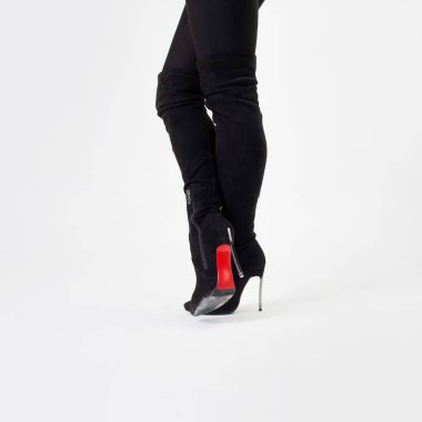 Siyah çizmeler ve pantolonlar içinde ince bacaklar. Yüksek topuklularla yürüyorum. Stiletto ayakkabılar