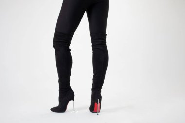 Diz boyu siyah çizmeler içinde ince bacaklar. Seksi tarz, vücut parçaları açık