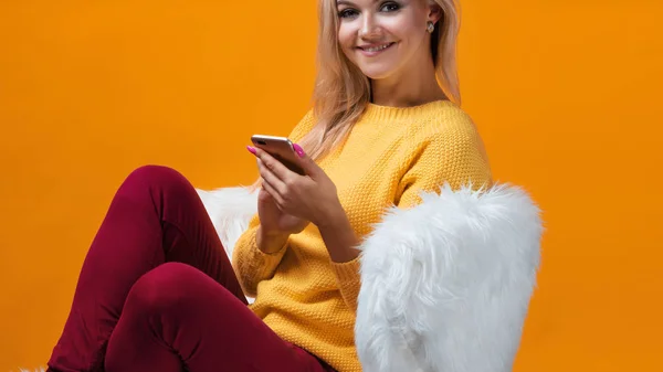 Rubia feliz y alegre utiliza un smartphone para comunicarse en las redes sociales — Foto de Stock