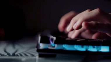 Karanlık bir odada arka plandaki klavyeye kod yazma programcısı, bilgisayardaki tutkulu çalışma.