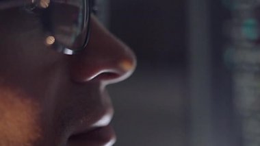 Monitörde çalışan programcı ve analist, kod yazıyor. Gözlüklerdeki monitör yansıması