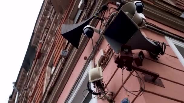 Retro loudspeakers and modern surveillance cameras on the corner of the house. — Stock Video