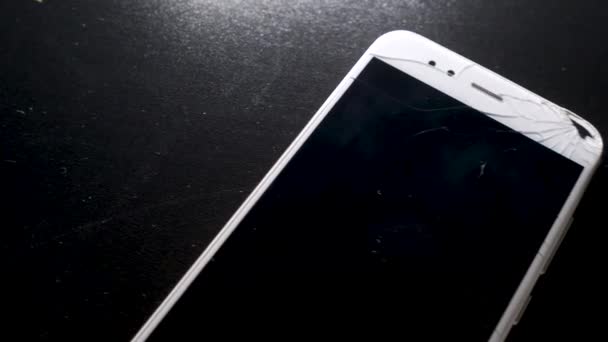 Gebroken smartphone scherm, een hand pakt een telefoon met een gebarsten display — Stockvideo