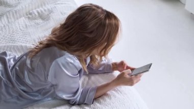 Genç bir kadın akıllı telefon kullanır, anında haberleşir ve mobil uygulamayı kullanır.